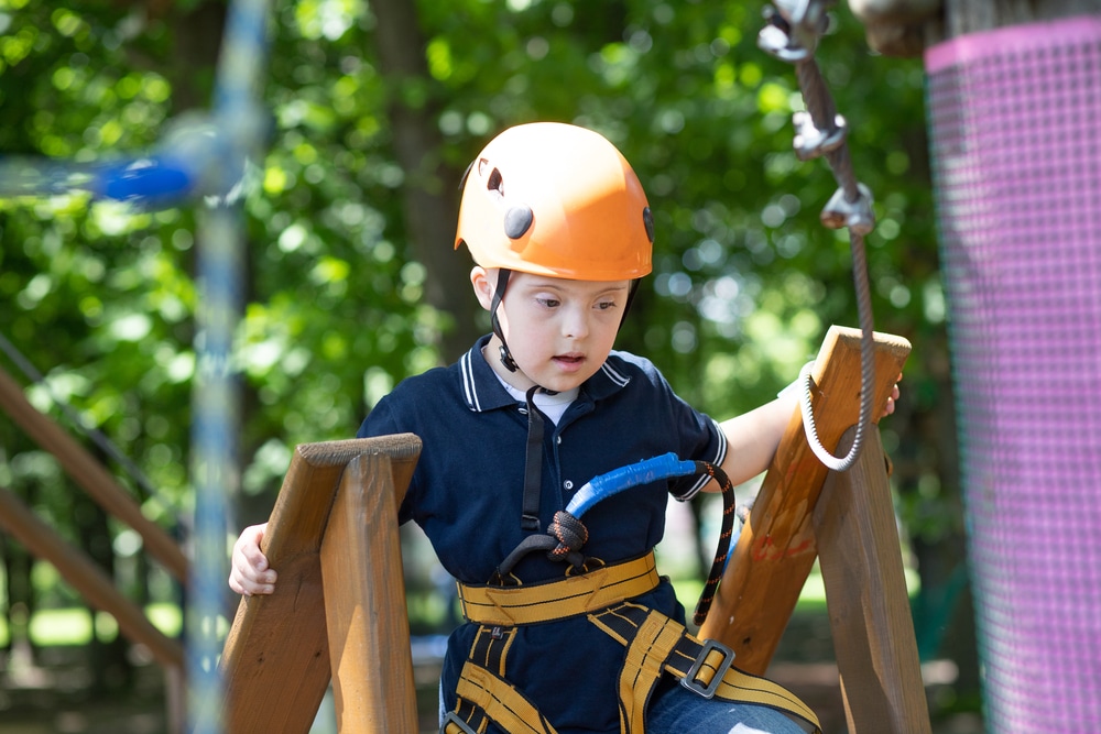 A,Happy,Boy,With,Down,Syndrome,In,An,Orange,Helmet ccessibilite-handicap-parcours-accrobranche-experia-park-benodet-pont-labbe-quimper-finistere